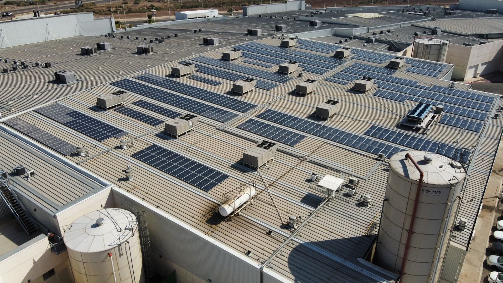 Instalación comercial con múltiples paneles solares en techo industrial